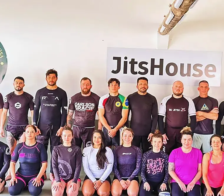 Turma reunida na frente do painel da JitsHouse ao fim de um treino.