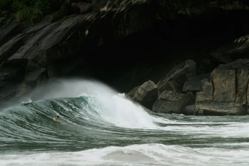 Onda quebrando contra as pedras da costa.