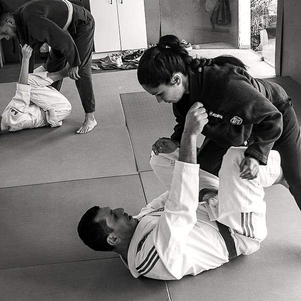 Rodrigo Klippel de kimono ensinando uma técnica no tatame.