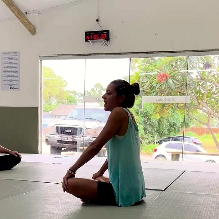 Prática de yoga sentada, de frente para a claridade da janela.