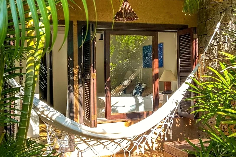 Rede armada na varanda entre plantas.