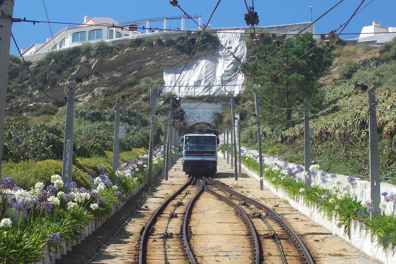O ascensor subindo os trilhos entre flores até o alto do Sítio.
