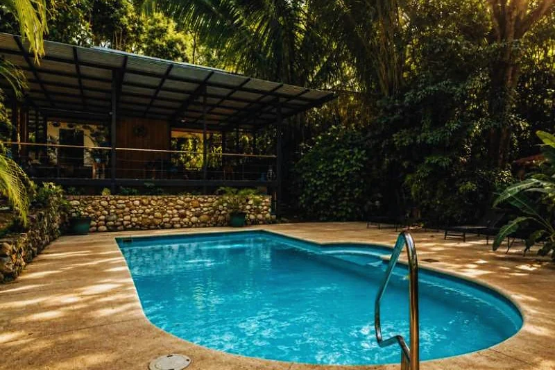 Piscina de pedra cercada pela mata tropical do hotel.