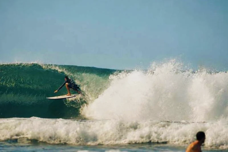 Surfista dentro do tubo de uma onda.