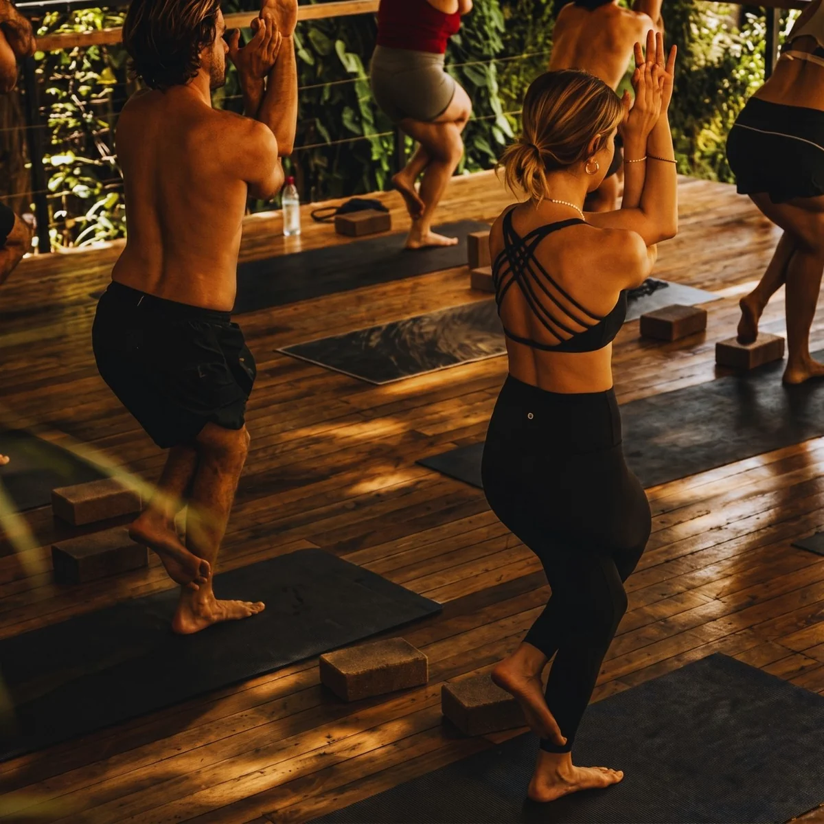 Grupo em prática de yoga no deck de madeira.