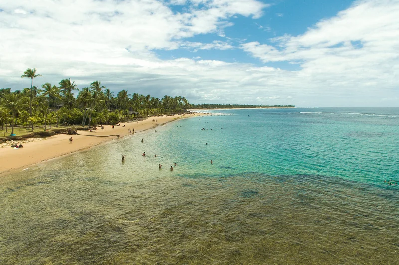 Piscinas naturais de água clara em Taipu de Fora, com o recife exposto na maré baixa.