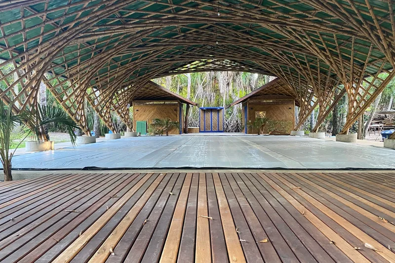 O Coliseo de dia, visto do deck de madeira: o tatame coberto sob a abóbada de bambu, com os vestiários ao fundo.